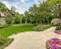 GARDEN : A recently completed country French estate in Dallas, Texas. This home features expansive gardens, stone walls, antique limestone paving, a raised pool, a putting green, fire pit and lush gardens