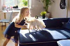 小女孩和两个月大的博美犬玩耍。可爱的主人和他的宠物。