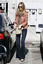 《变3》女郎罗西·汉丁顿-惠特莉(Rosie Huntington-Whiteley)身穿红色夹克，拎着Mulberry斜挎包出现在西好莱坞街头。茶色墨镜来自Burberry，高跟及踝靴来自Rag & Bone。