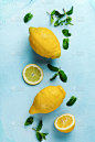 两个新鲜的柠檬在蓝色盘子上，在绿松石混凝土背景。食品的背景。前视图。