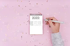 题字写在一个白色的笔记本上。女人为明年写计划