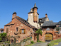 This may contain: an old brick building with a clock tower on the top of it's roof