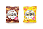two bags of food sitting next to each other on a white surface and one bag is filled with nuts