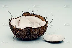 椰子的一部分在一个彩色的背景。关闭了。新鲜成熟的椰子碎成碎片。