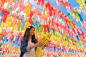 一幅亚洲妇女的肖像与五颜六色的灯笼或灯在旅游旅行和假期的概念。传统节日，在哈利库尔猜寺，兰汶，泰国。