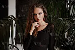 一个迷人的红头发卷发女孩的肖像，穿着黑色皮夹克