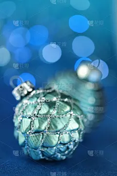 圣诞节和新年的装饰。绿色节日球装饰在深蓝色的背景与闪光的散焦。冬天的节日背景。电话圣诞壁纸。冬天的假