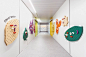 the hallway is lined with brightly colored pegboards and colorful wall hangings on the walls