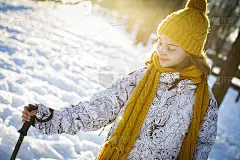十几岁的女孩拄着拐杖在雪地里走