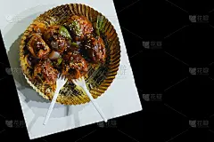 烤鸡煎馍，纸盘上有酱汁，黑色背景的塑料勺，印度加尔各答街头小吃