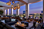 Candlelit rooftop lounge at dusk with city view.