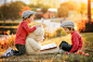 Two adorable little boys with his teddy bear friend in the park