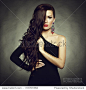 Portrait of beautiful brunette woman in black dress. Fashion photo