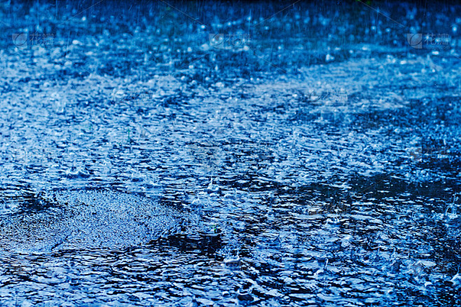 雨点落在街道路面上，在雨天，色调是蓝色的