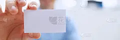 西装革履的微笑商人手里拿着空白的名片