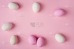 复活节彩蛋散布在粉红色的背景和上面的拷贝空间