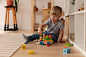 Full shot kid playing with wooden toy at home Free Photo