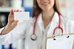 一位女医生在她的诊所前拿着白色的名片