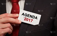 商人把一张写着2017年议程的卡片放在口袋里
