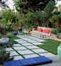 Elysian Landscapes transformed this simple backyard space into an open-air living room. Similar to an interior palette, the green in the surrounding landscape provides a background color, while blue and coral cushions offer bright accents.