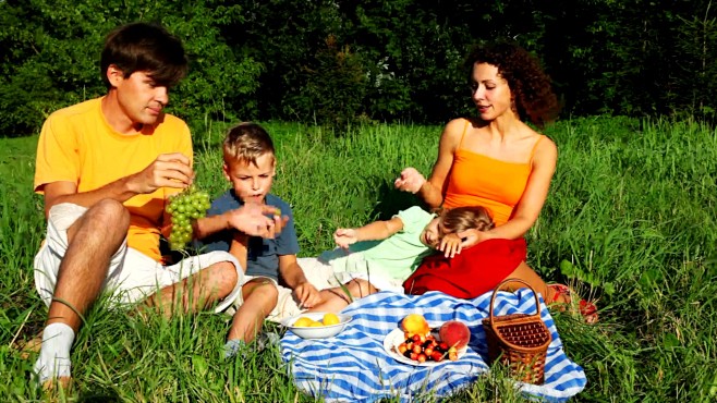 一家人坐在草坪上吃水果