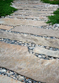 Irregular stone slabs laid with pebbles between them.