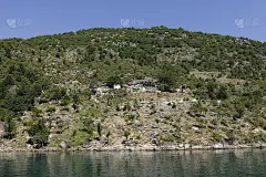 在阿尔巴尼亚第纳尔阿尔卑斯山脉的科马尼湖上乘船旅行，沿途有美丽的山脉和绿色的森林