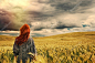 时尚年轻的红头发女人站回户外领域戏剧性暴风雨天空的美景