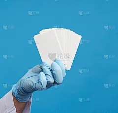 医生在蓝色医用乳胶手套中手持一张空纸名片