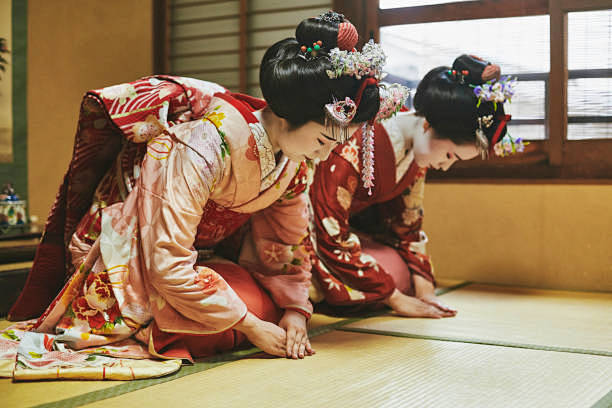 日本の伝統的な舞妓ひざまずき、お辞儀 -...