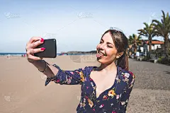 一名年轻女子在海滩边用手机自拍