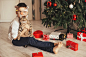 快乐的小男孩的肖像头带与圣诞老人的帽子和滑稽的眼镜与圣诞树在绿色的墙壁上摆姿势。圣诞快乐，新年快乐，孩子。图片下载