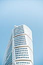 a tall white building with a blue sky in the background