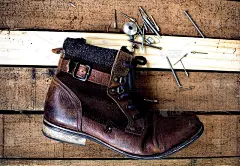 棕色皮靴和木质地板上的鞋刷