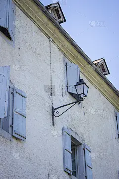 带有室外过滤灯的中世纪建筑。带有百叶窗的旧房子正面。古代建筑的概念。法国村庄的历史建筑。
