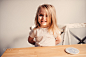 happy toddler girl having breakfast at home