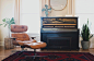 A leather chair with a footstool next to a piano with an exposed soundboard