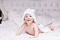 可爱的婴儿躺在床上白色的毛巾。快乐童年，健康理念。