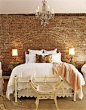 Love the white bedding with exposed brick & crystal chandelier <3