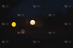 在黑色背景上抽象黄色和白色的散景纹理。散景七彩光泽闪耀美丽的情人节概念。新年的一天。