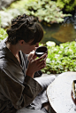 Photograph Caucasian woman in robe drinking tea in zen garden by Gable Denims on 500px