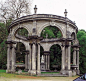 This may contain: a car parked in front of an old stone structure with arches and statues on it