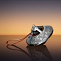 This may contain: a silver and black object with a red cord attached to it's side on a reflective surface
