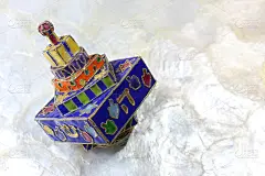 节日彩色搪瓷光明节dreidel在柔软的白色背景