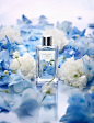 odafoe perfume surrounded by blue floral elements, in the style of soft-focused realism, leica i, light-filled, larme kei, transparency and lightness, whistlerian, advertisement inspired