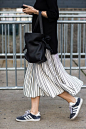 Adidas kicks with a graphic pleated skirt and leather bucket bag.