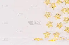 圣诞节空白的室内与发光的灯光，金色的星星在白色的木头背景。