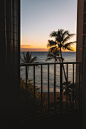 a view of the ocean from a balcony at sunset