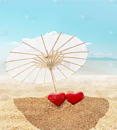 情人节贺卡。两颗心-象征爱情的情侣在沙滩上天堂热带沙滩上撑着阳伞。背景是蓝色的大海和天空。爱,在一起