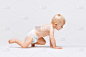 可爱的小女孩的肖像，婴儿在尿布爬行孤立的白色工作室背景